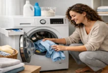 Çamaşır makinesine çamaşır yerleştiren kıvırcık saçlı kadın